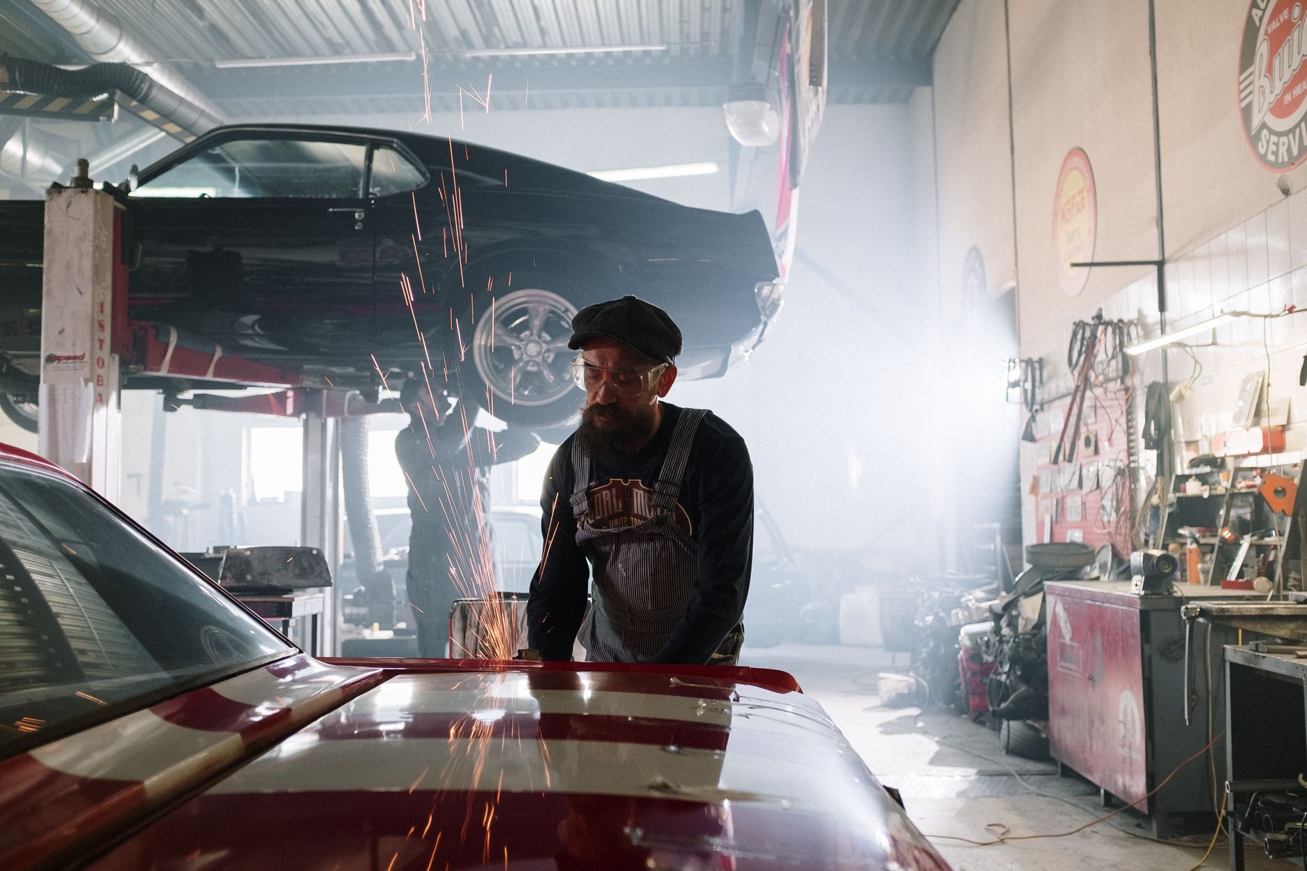 Mechanic working on vintage car with sparks