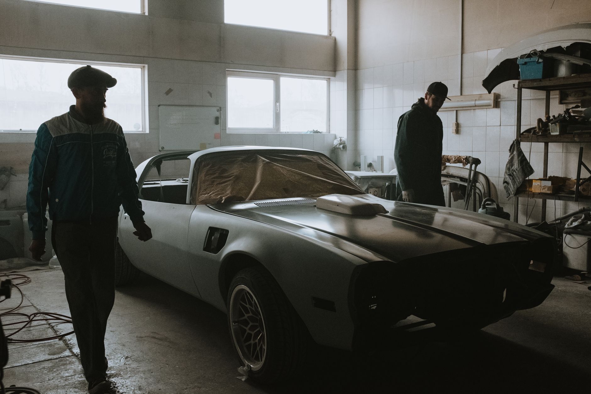Mechanics restoring a classic car in the workshop